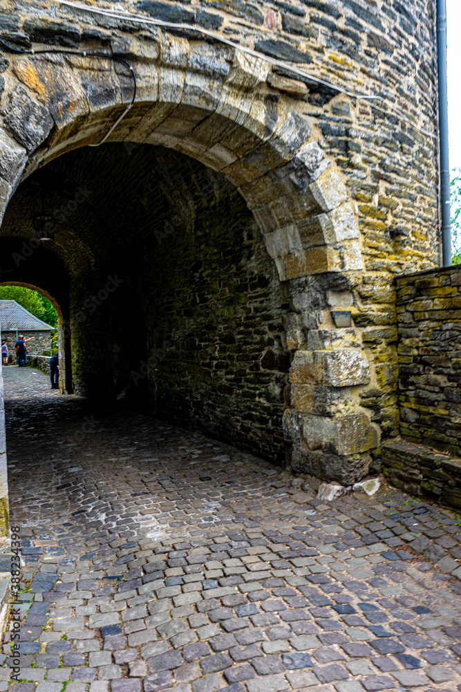 Obraz premium Germany, Monschau, a stone building that has a bridge next to a brick wall