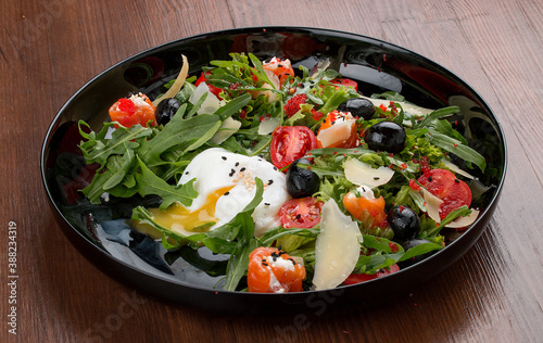 Salad with salmon and cheese rolls, arugula and poached egg.