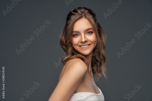 Beauty portrait of cheerful young model with long curly hair