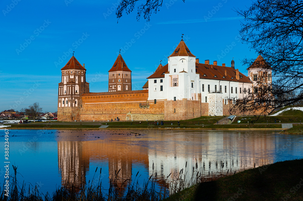 View of impressive medieval Castle surrounded by ponds in Belarusian town of Mir on winter day