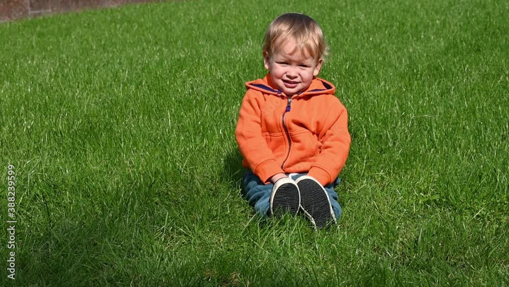 Little boy playing with football ball on grass Little boy playing with football ball on grass