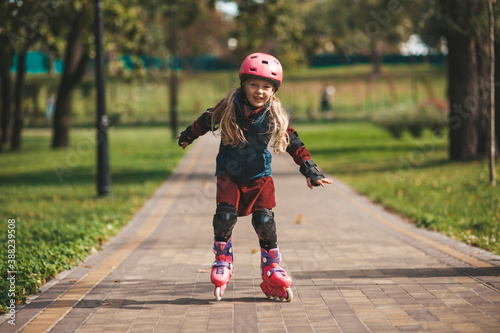 Cute little girl in a helmet rollerblading, protection during sports and entertainment.