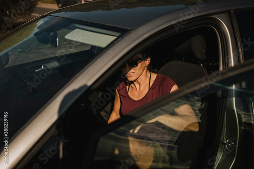 Woman entering in a car on the driver seat