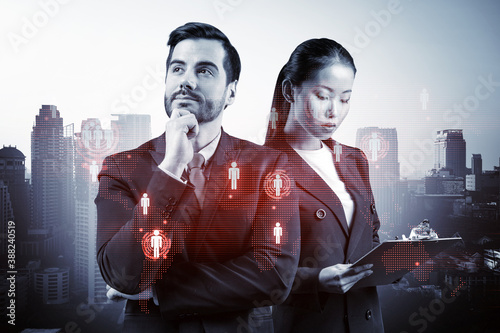 Businessman and businesswoman as a SMM specialists thinking about development of social media marketing strategy to achieve business goals. Hologram icons over Bangkok background. photo