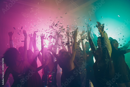 Photo of big group many fancy ladies dance raise hands falling confetti neon vibrant spotlight modern club indoors