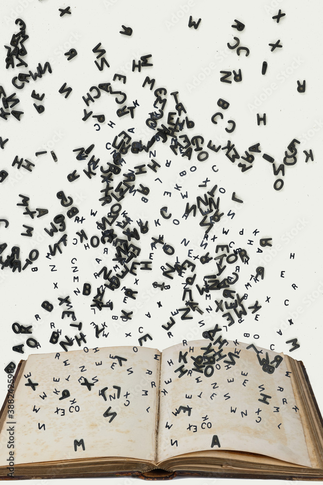 Letters of the alphabet in levitation in the air over the open book