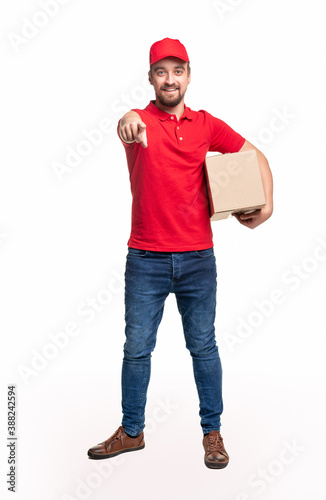 Positive delivery man pointing at camera