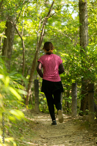 秋の朝の公園でジョギングしている若い女性の姿