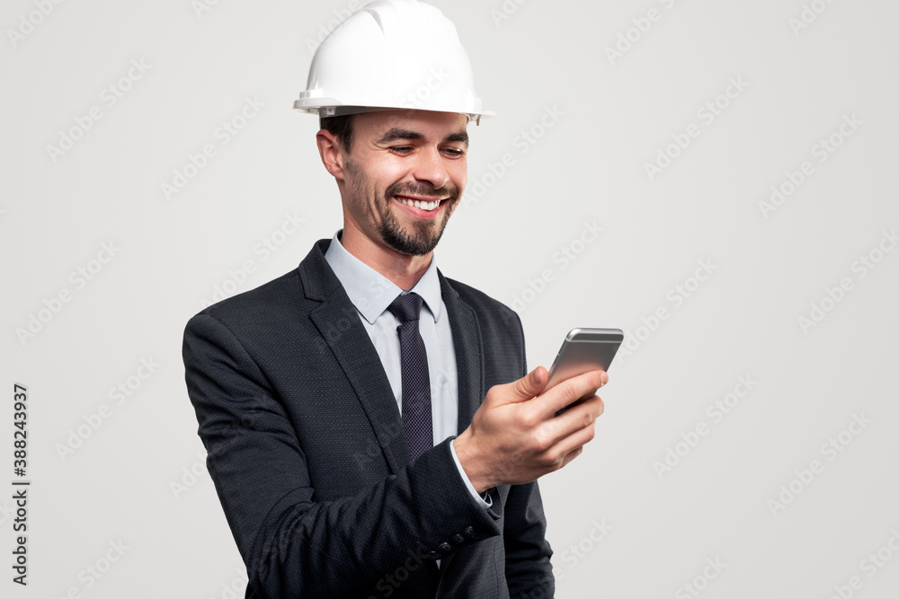 Happy male engineer using smartphone Happy male engineer using smartphone
