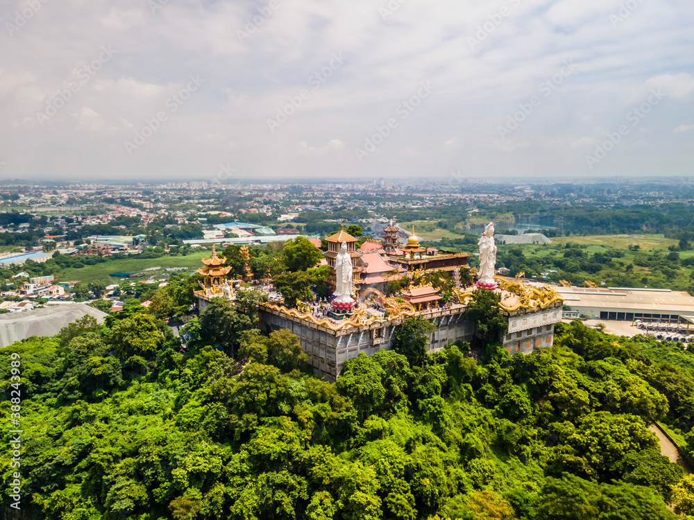 Aerial view of bodhisattva architecture and double sky dragon in Chau Thoi pagoda, Binh Duong province, Vietnam in the afternoon with sun through cloud create auspicious buddha.
