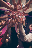 Vertical cropped concept photo portrait low below angle of people clinking champagne and cocktail glasses