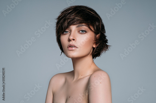 Fototapeta Portrait of a young beautiful brunette girl with stylish short hair