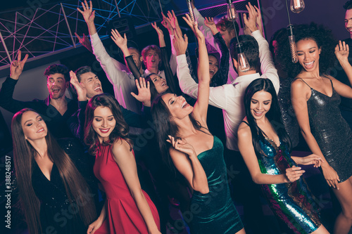 Photo portrait of guys and girls dancing together at club raising hands up