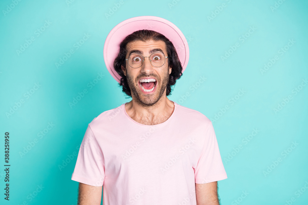 Photo portrait of crazy amazed man shouting loudly wearing pink t-shirt headwear spectacles isolated on vivid turquoise color background
