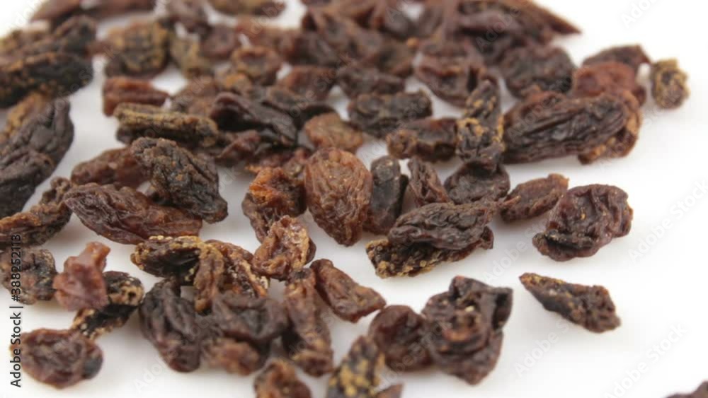 Close-up a handful of sweet raisins rotate on a white background.Sweet organic raisins rotate on a plate. Raisins rotate on a white background. Close-up a handful of sweet raisins rotate on a white background.Sweet organic raisins rotate on a plate. Raisins rotate on a white background.