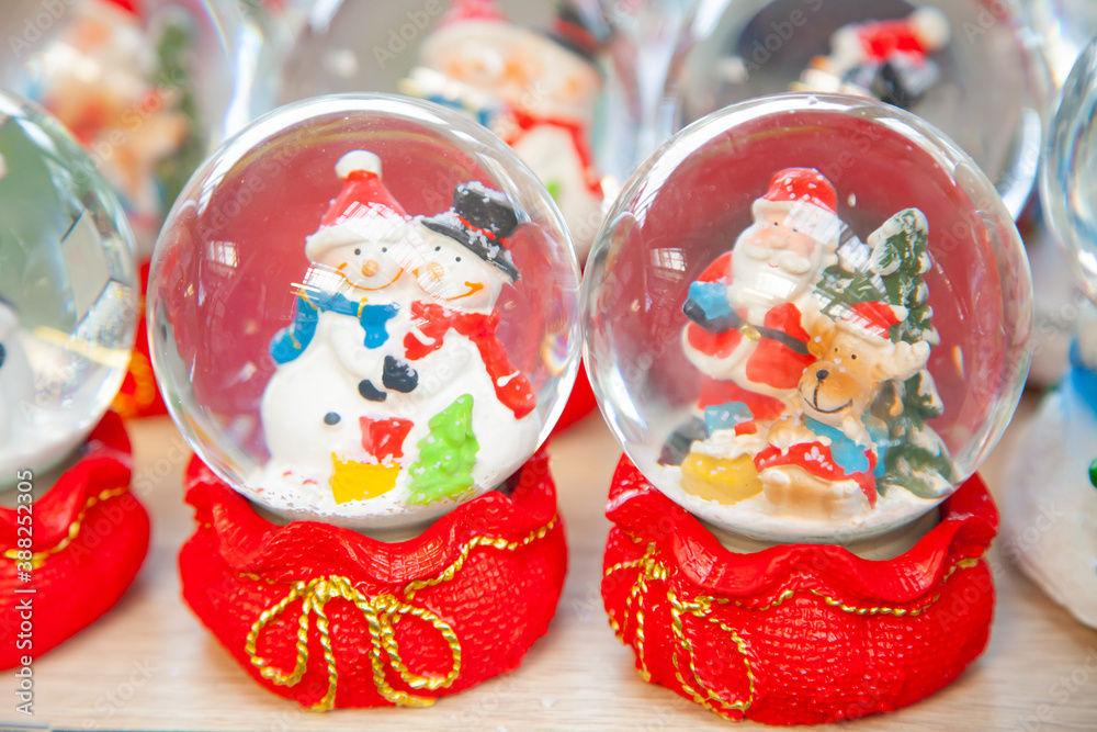 Various traditional Christmas balls with water inside and Santa Claus. Christmas showcase in supermarket, home decoration