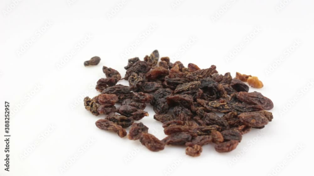 Close-up a handful of sweet raisins rotate on a white background.Sweet organic raisins rotate on a plate. Raisins rotate on a white background. Close-up a handful of sweet raisins rotate on a white background.Sweet organic raisins rotate on a plate. Raisins rotate on a white background.