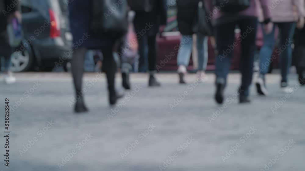 Lens blur, out of focus. Hurrying crowd of pedestrians crossing the street during rush hour. Crowded crosswalk. City life scene. A crowd of people on the background of cars. Slow motion. Lens blur, out of focus. Hurrying crowd of pedestrians crossing the street during rush hour. Crowded crosswalk. City life scene. A crowd of people on the background of cars. Slow motion.