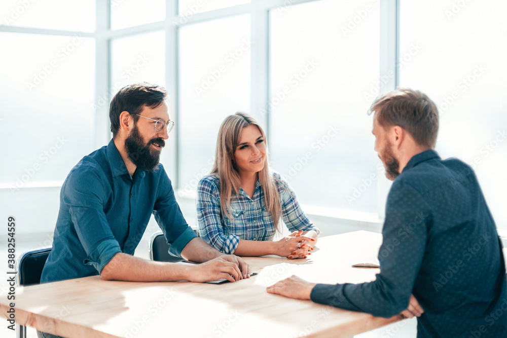 group of successful young people sitting at the negotiating table.