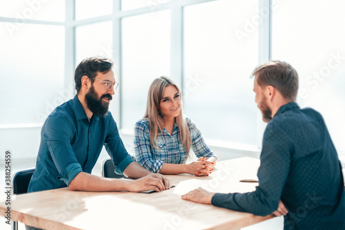 Obraz na płótnie group of successful young people sitting at the negotiating table. w salonie