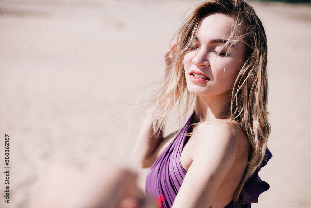 Young, slender girl with purple cloth poses in the desert Young, slender girl with purple cloth poses in the desert