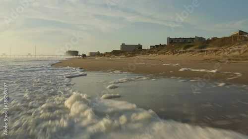 Drone flying up beach in Oak Island showing the beauty of the sand, shore and all the wonderful views. photo