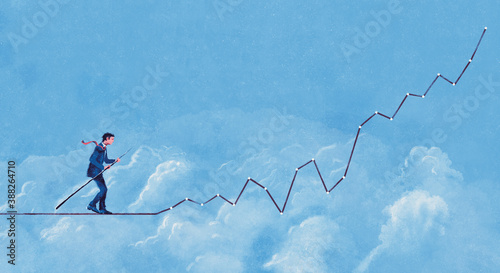 Businessman walking along graph as tightrope in sky photo