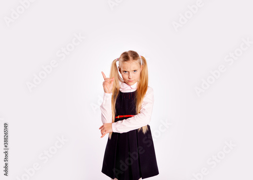 distrustful schoolgirl planning something straightens her hair