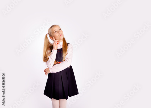 distrustful schoolgirl planning something straightens her hair