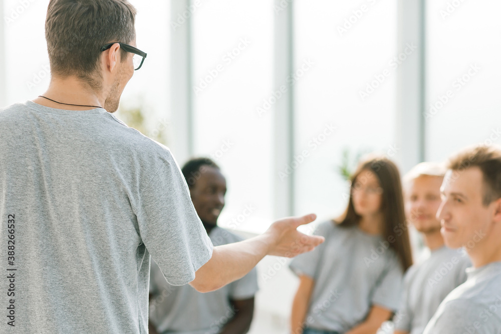close up. business coach holds a debate with a group of young people close up. business coach holds a debate with a group of young people