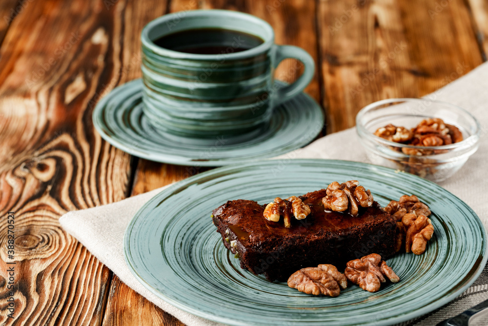 Piece of chocolate cake with nuts on green plate Piece of chocolate cake with nuts on green plate