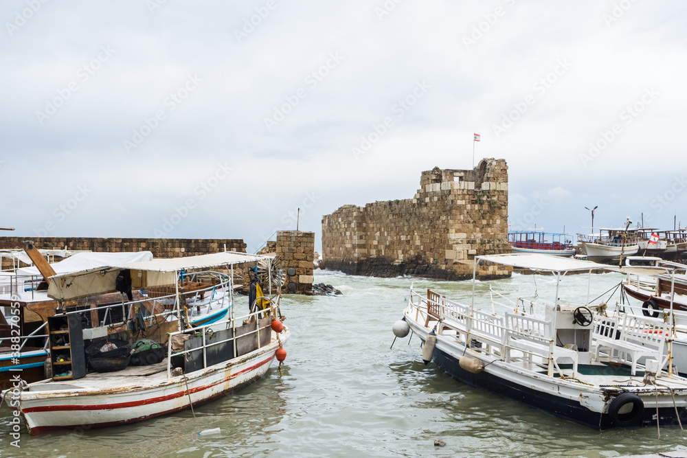 Small boats at Byblos harbor with ruins in the background, Jbeil