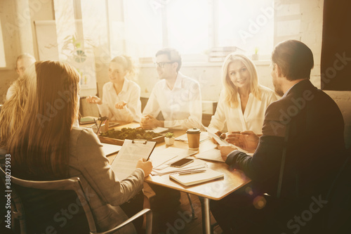 Photo partners investors man woman sit table have way-out crisis company development strategy briefing tell talk say speak cost economy reduction solution in boardroom workplace workstation