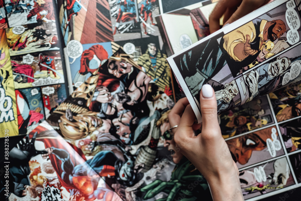 Naklejka premium hand flipping through comic book pages. Comics background. Rostov-on-Don, Russia. 1 August 2019