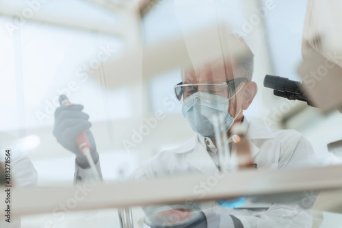 scientist sitting using an automatic dispenser for his research.