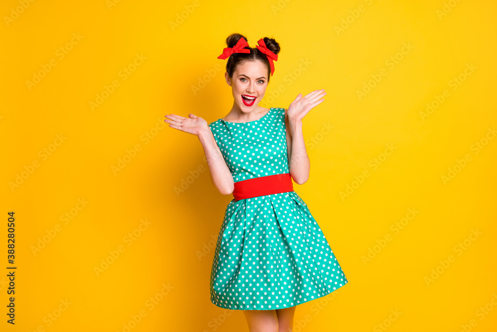 Portrait of charming cheerful girl wearing dotted dress enjoying clapping palms isolated over bright yellow color background Portrait of charming cheerful girl wearing dotted dress enjoying clapping palms isolated over bright yellow color background