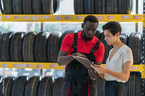 A technician provide service and talking to a customer in the auto service canter/tires service center