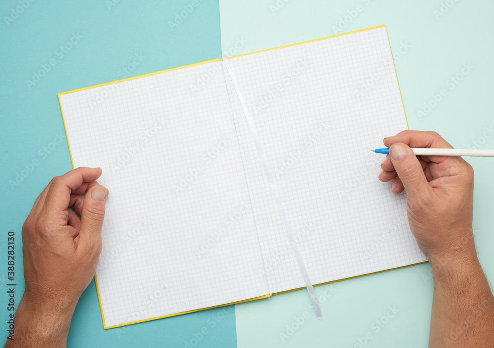 two male hands holding open notepad with empty white sheets two male hands holding open notepad with empty white sheets