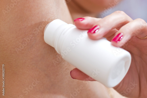Girl applying stick deodorant in armpit