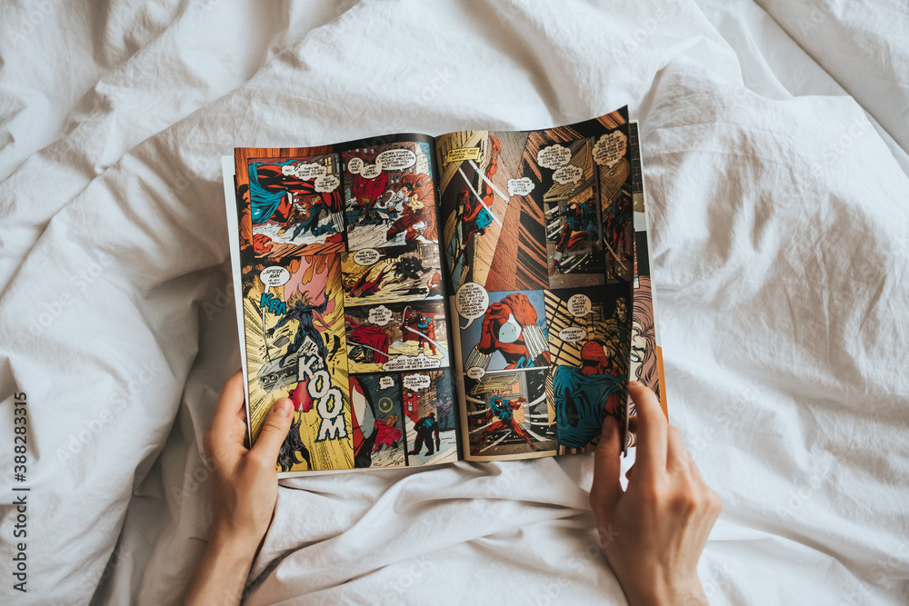 Obraz premium Woman reading comic book in the bed at home. Rostov-on-Don, Russia. 14 April 2020