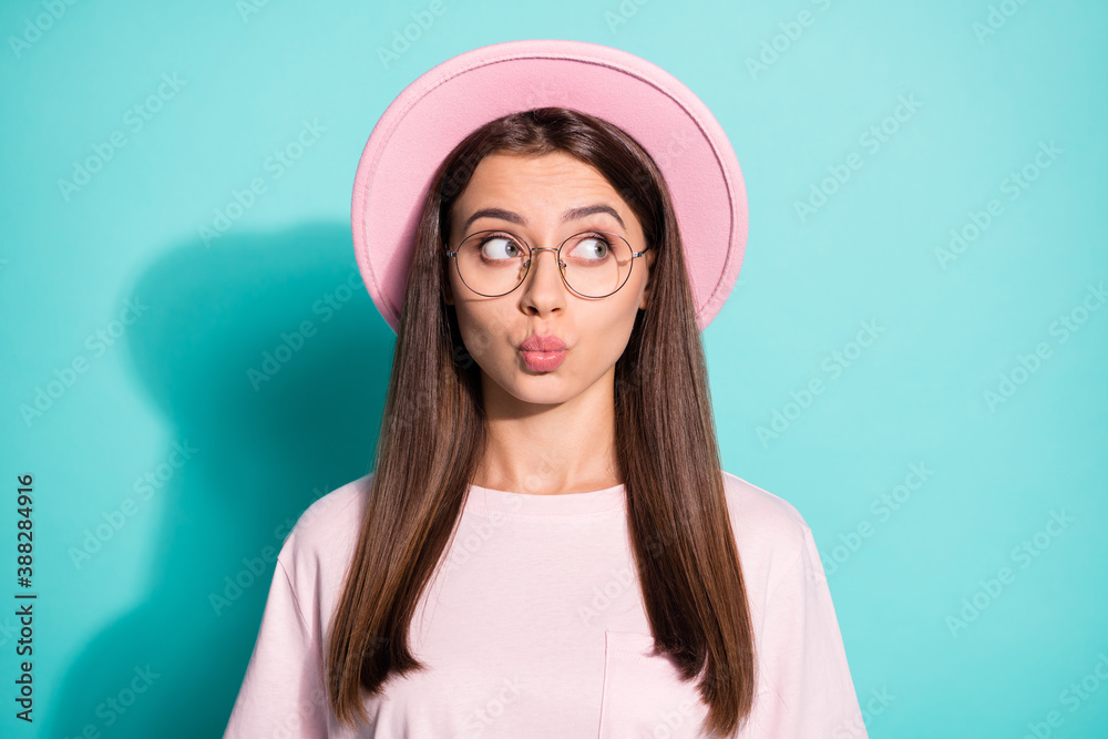Photo of cute tricky girl lady dressed pink t-shirt hat pouted lips look empty space isolated teal color background Photo of cute tricky girl lady dressed pink t-shirt hat pouted lips look empty space isolated teal color background