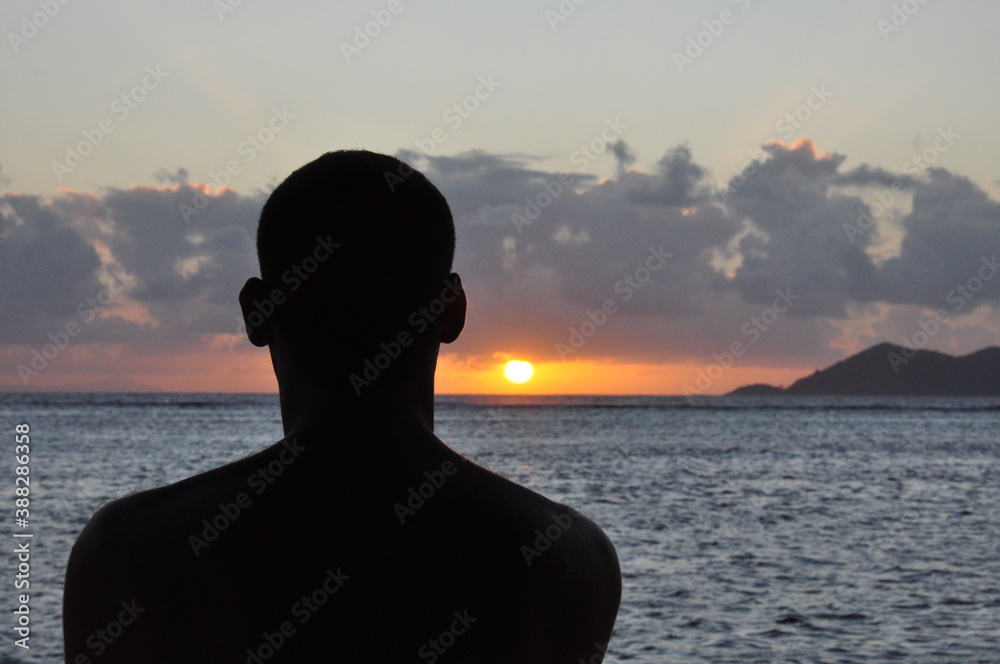 Silhouette of a head man from the back at sunset with the sea