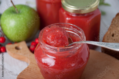 Fototapeta Naklejka Na Ścianę i Meble -  Rowan and apple jam in a teaspoon on jar of jam