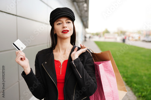 Attractive young woman with a credit card and shopping bags