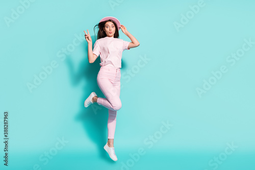 Fototapeta Naklejka Na Ścianę i Meble -  Full length body size view of her she nice attractive pretty cheerful girl jumping having fun pout lips showing v-sign isolated bright vivid shine vibrant green turquoise color background