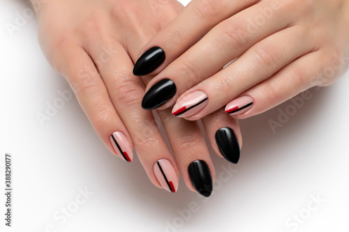 Black manicure with stripes on long sharp nails close-up on a white background. Autumn manicure.