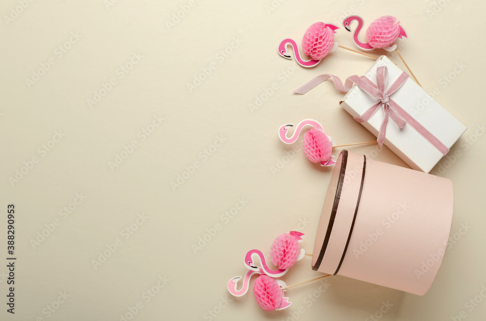 Top view of several present boxes, decorative flamingoes on the beige desk.Empty space