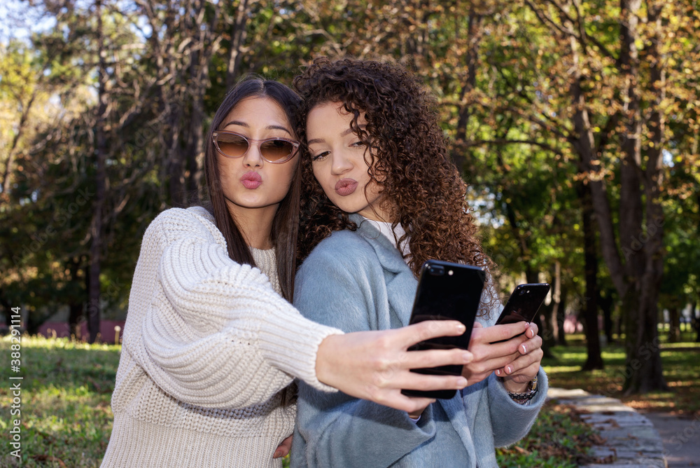 Two young girls taking selfie using smartphone Two young girls taking selfie using smartphone