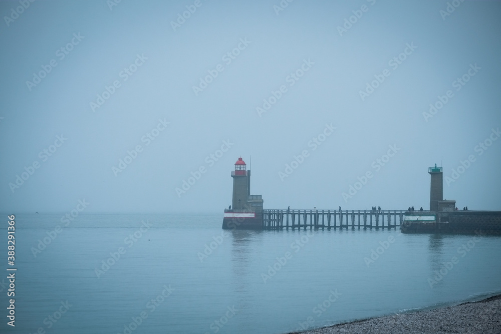 The lighthouses that form a beacon in the port of Fecamp, Normandy, France on a grey and misty day