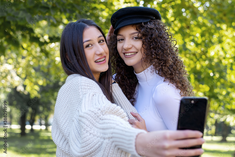 Two young girls taking selfie using smartphone Two young girls taking selfie using smartphone